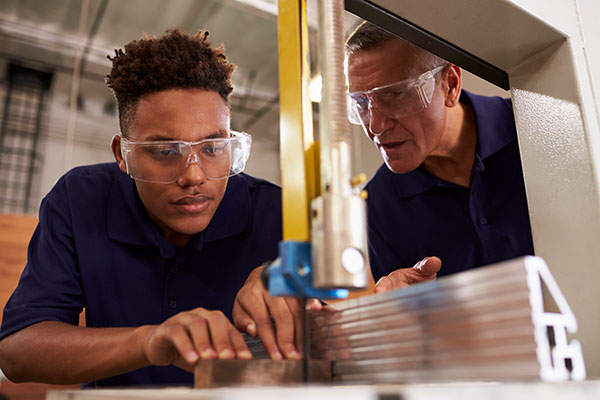 Instructor working with a student using a bandsaw